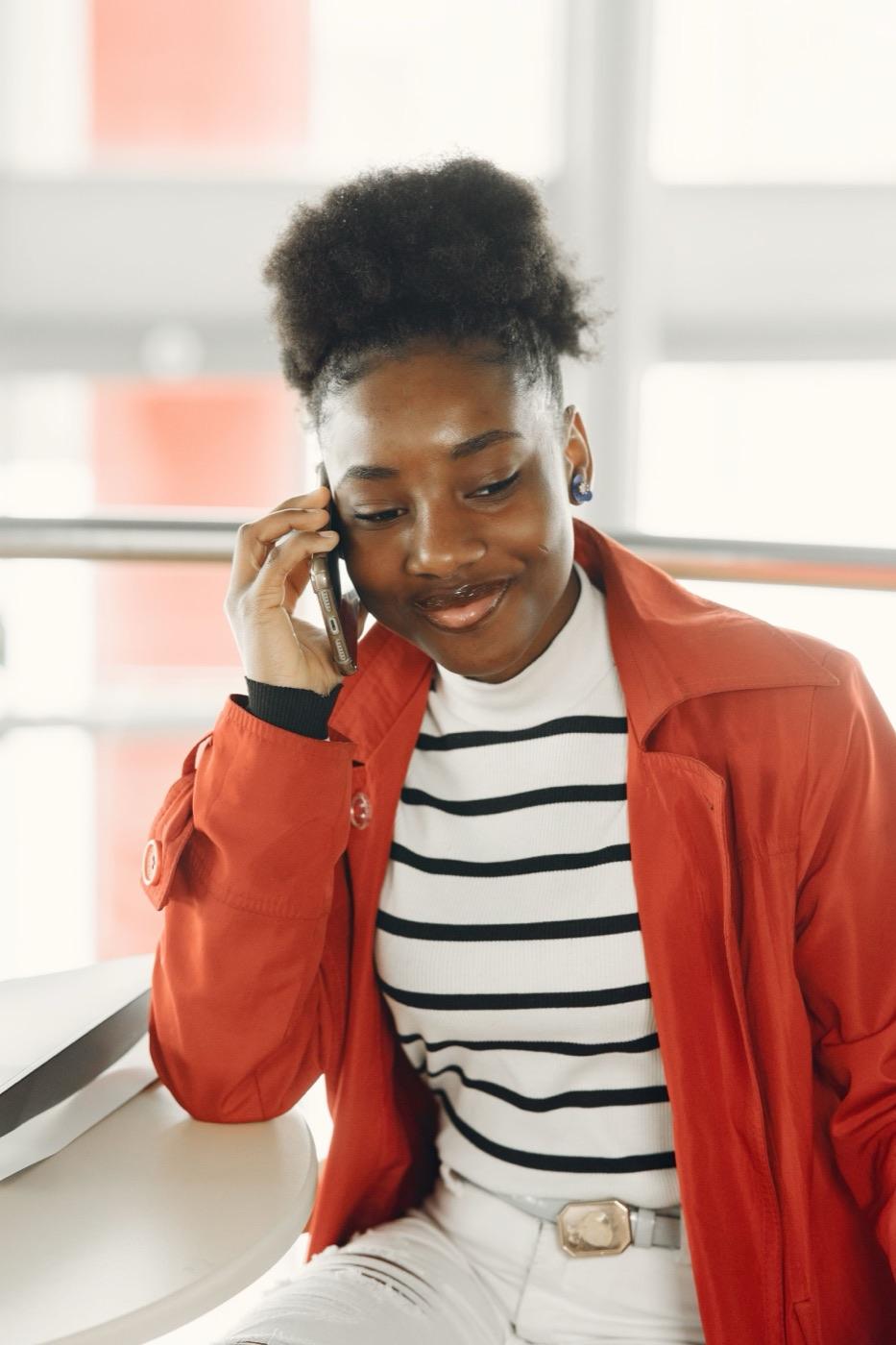 A woman smiling during a phone call.