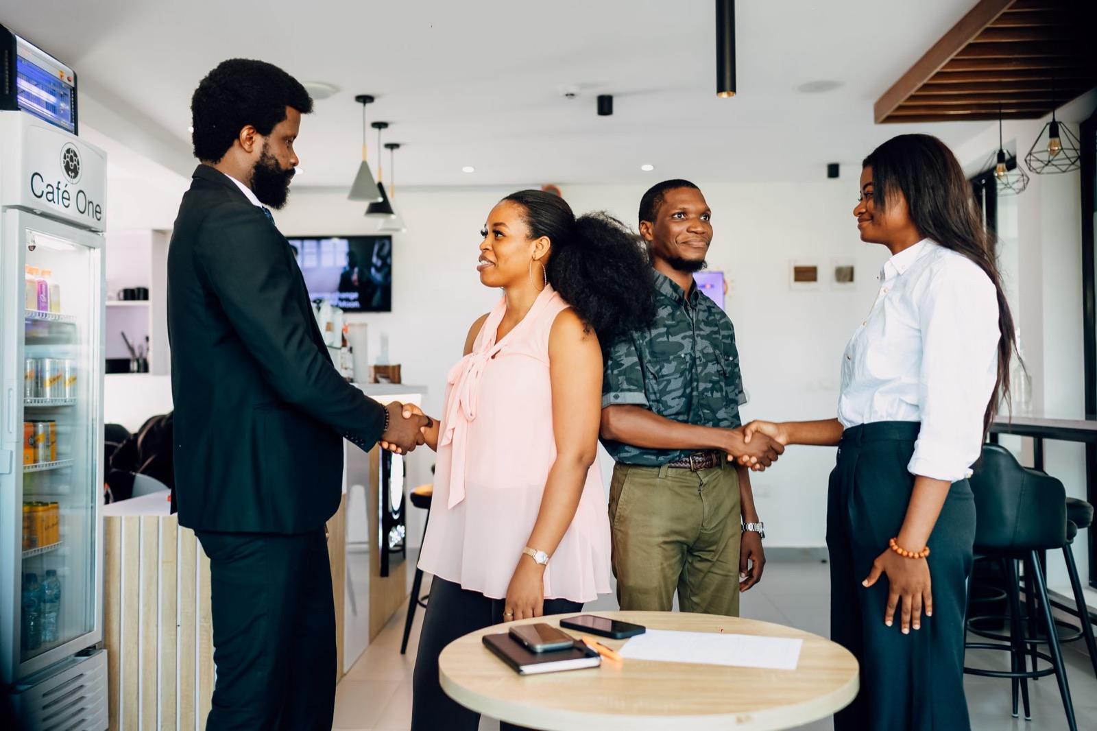 Four people shaking hands at a meeting in Lagos.